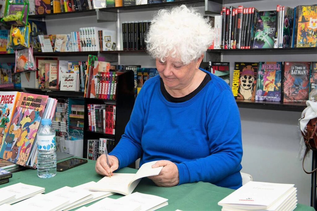 Aquí se puede ver como Lola Callejón está firmando uno de los Poemarios de El Porvenir